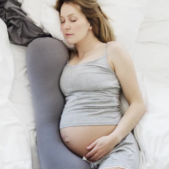 Pregnant woman in bed with support pillows